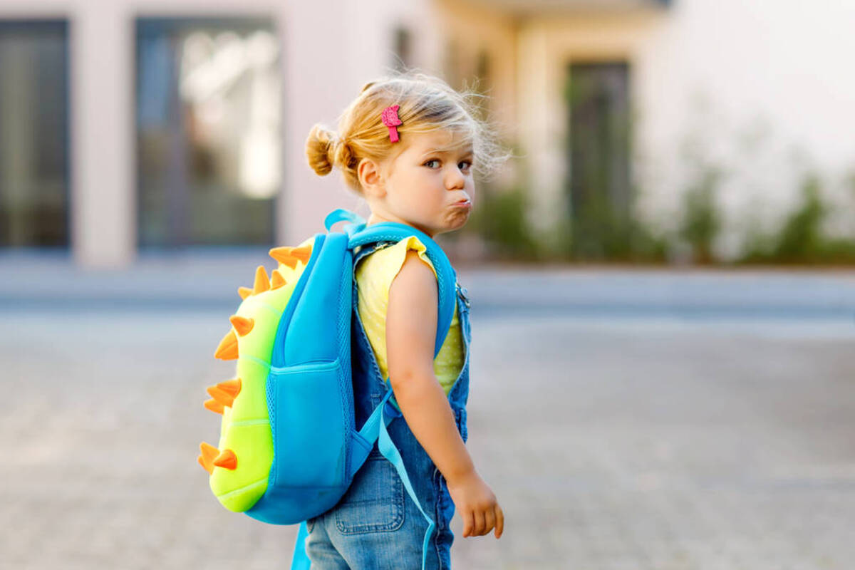 petite fille sac au dos avec la mine renfrognée