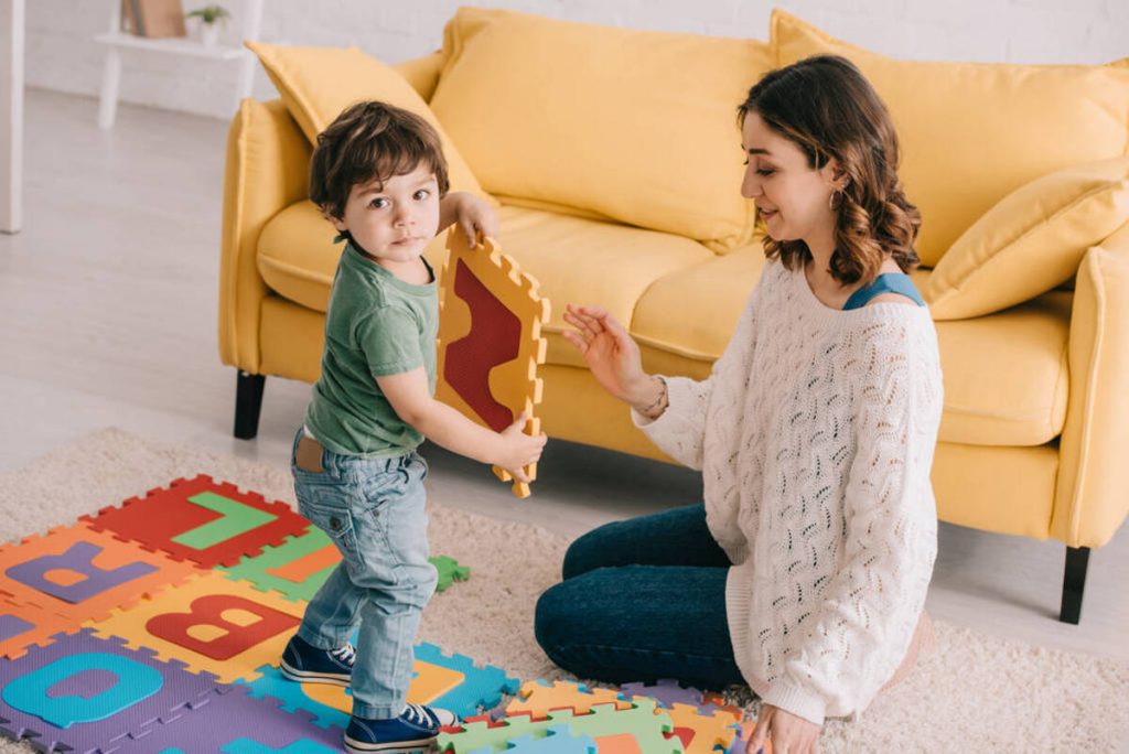 Maman et enfant jouent à un jeu de puzzle