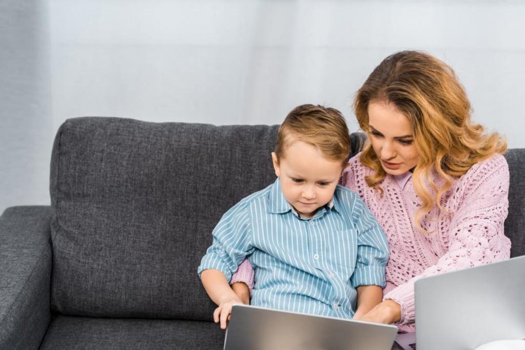 Maman apprend à lire à son enfant sur ordinateur